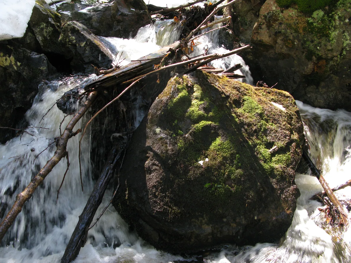 Water cascading around the large boulder