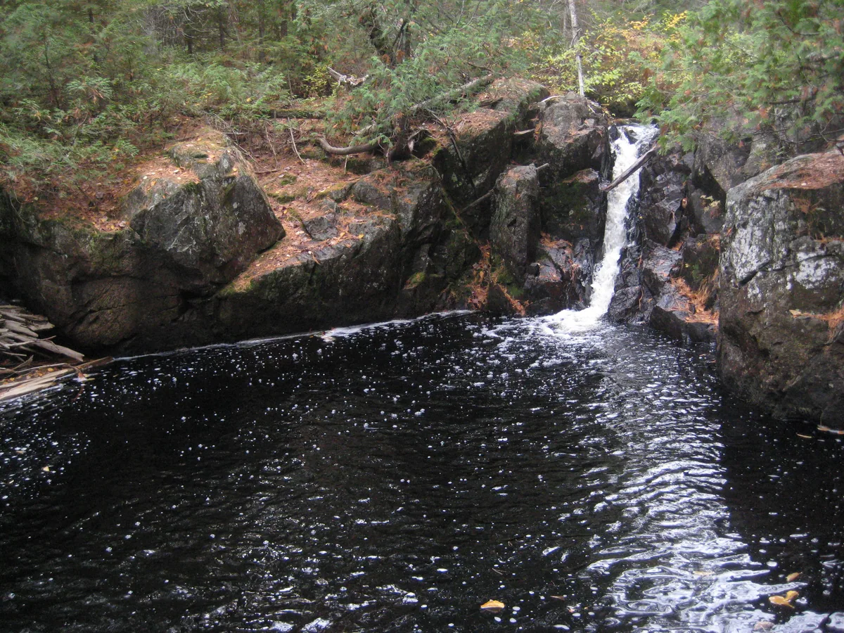 Tiny chute emptying into a deep pool
