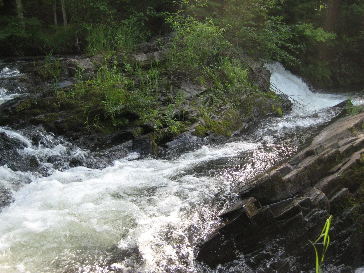 Water running around the slanted rocks