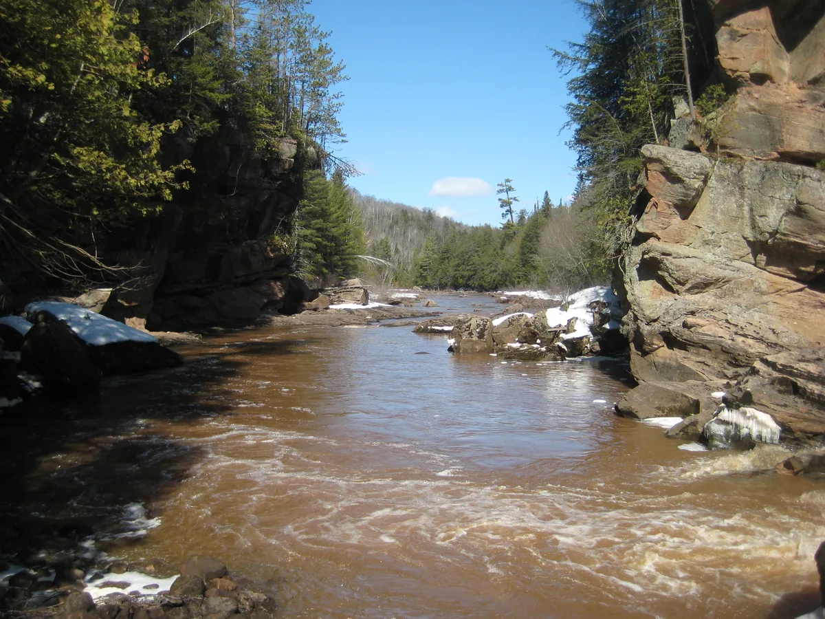Down the brown flow of water